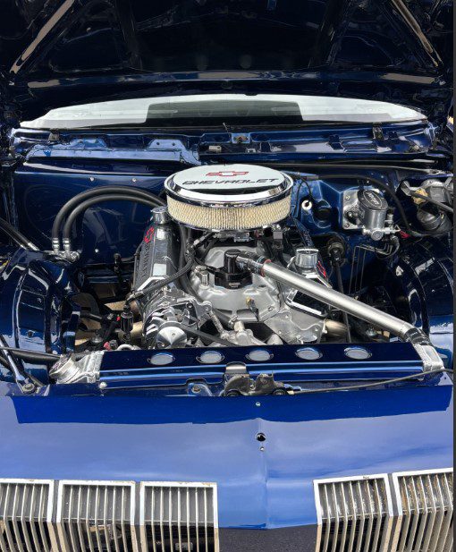 Clean, restored Chevrolet engine in a blue vehicle hood open for inspection, showcasing expert collision repair and quality auto body work by Kelley’s Auto Body serving Cedar Rapids and nearby communities.