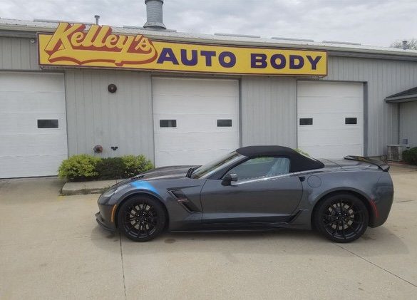 kellysauto Gray convertible sports car parked in front of Kelley’s Auto Body shop with yellow and red signage, showcasing expert auto body repair services and trusted insurance collaboration in Cedar Rapids.